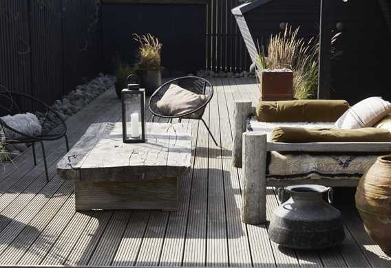 Træterrasse med rustikke møbler designet af havearkitekt Tor Haddeland
