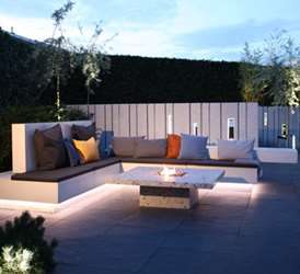 Loungemoebel med granitmur som afskaermning tegnet af havearkitekt Tor Haddeland