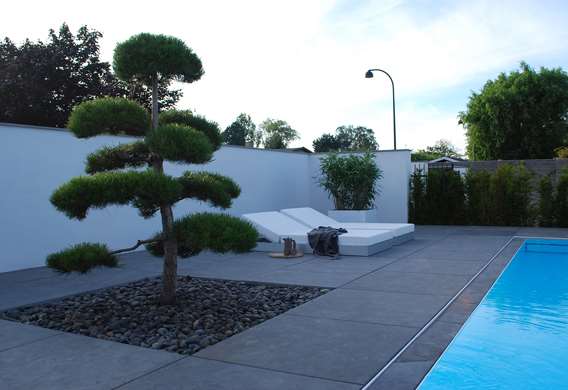 Havearkitekt Tor Haddeland tegner terrasse med store kvadratiske natursten omkring pool